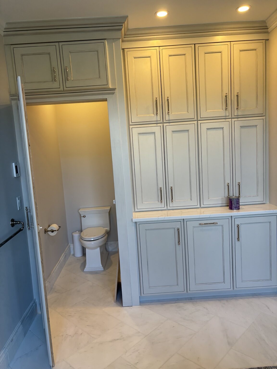 Custom bathroom storage cabinetry surrounding a recessed opening