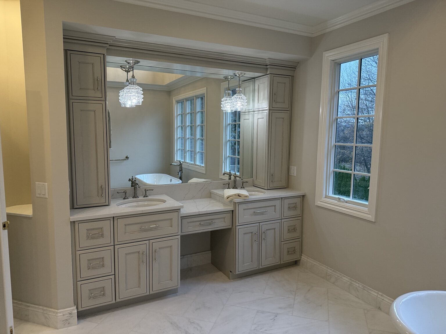 Painted bathroom vanity with twin sink cabinets and a central makeup station
