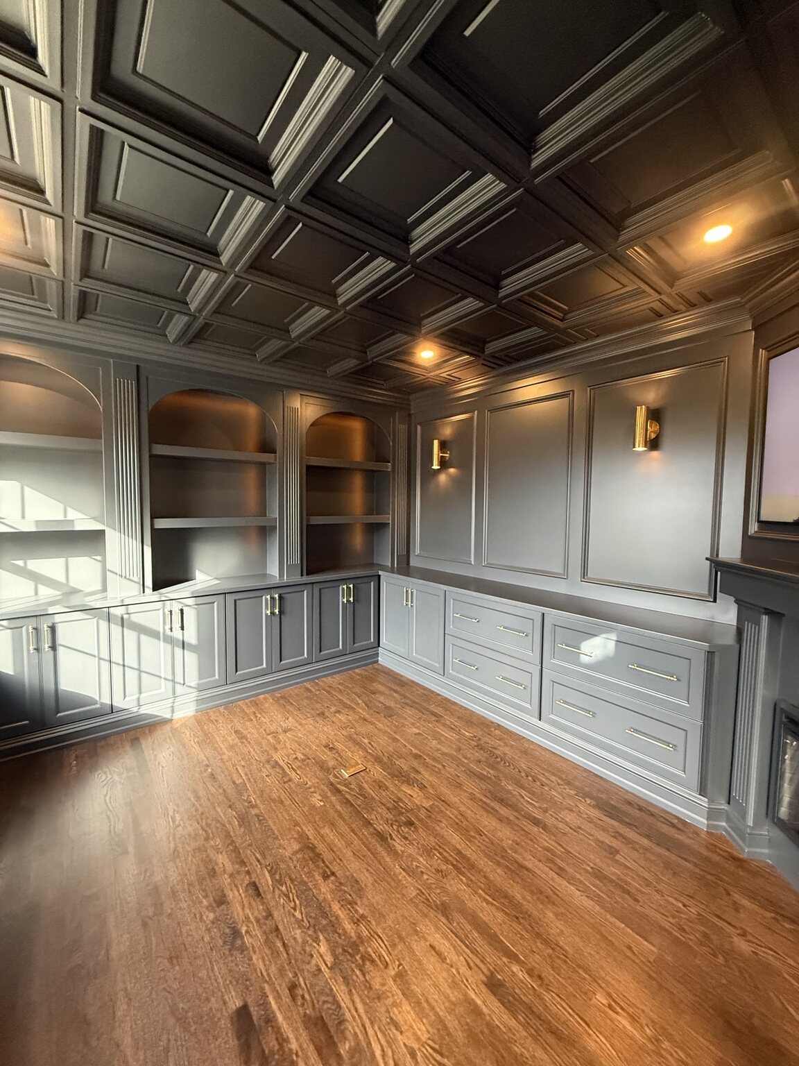 Detailed coffered ceiling above coordinated wall panels and cabinetry