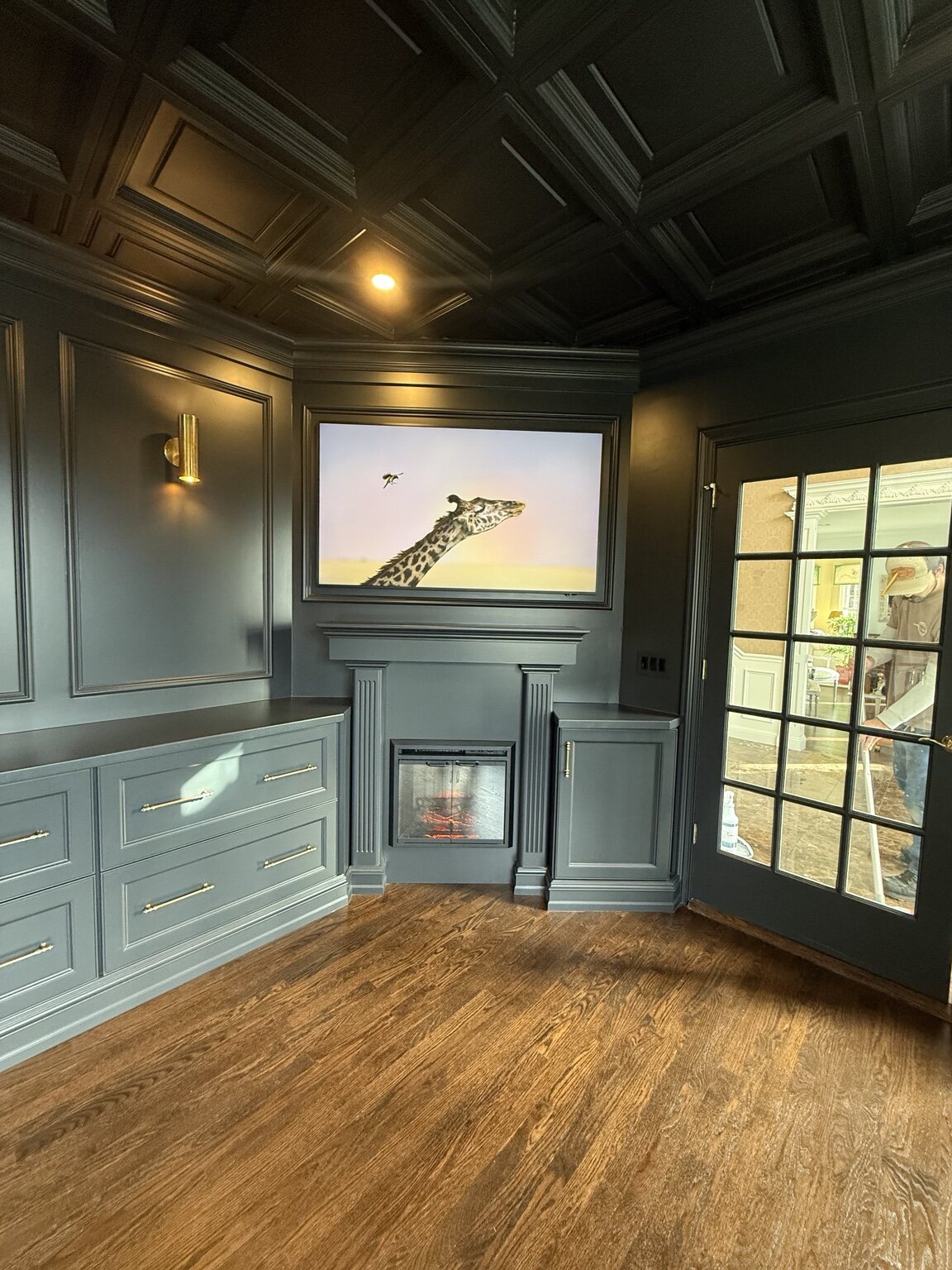 Library fireplace framed by painted wall panels and drawer cabinetry